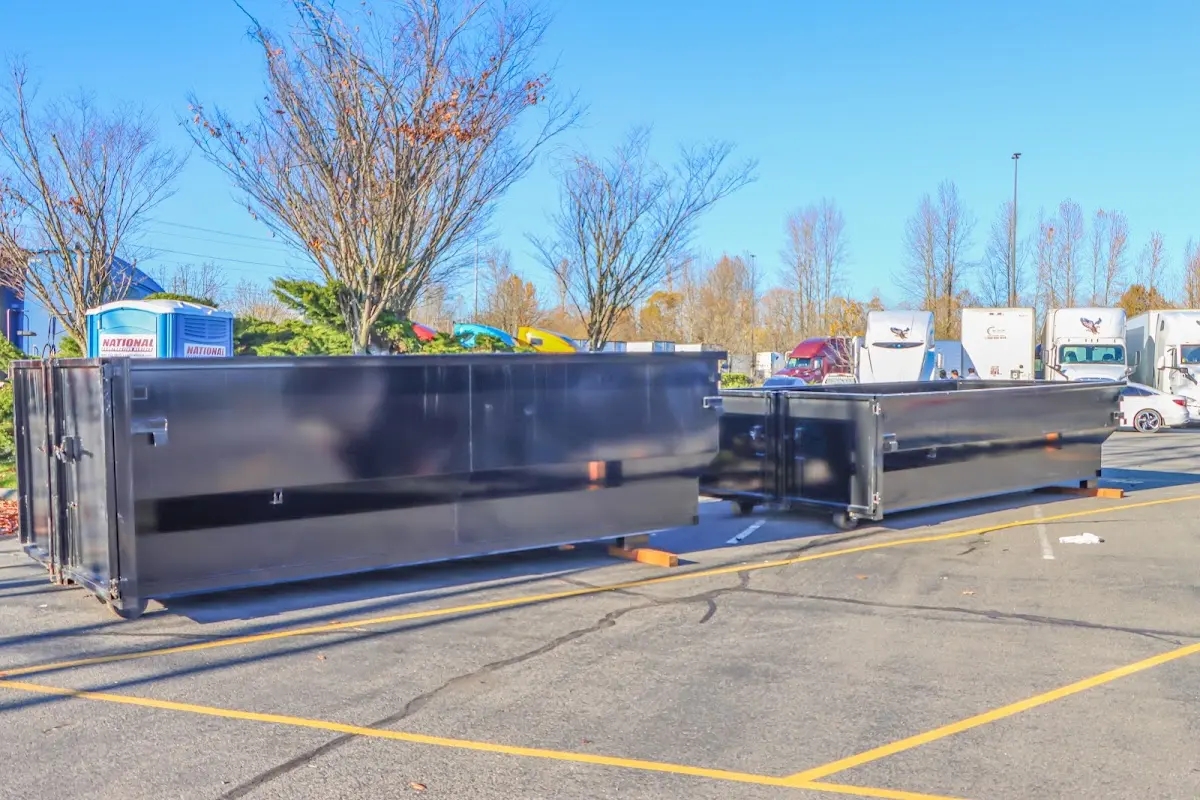 Professional dumpster rental service with roll-off container on residential driveway in Somerton